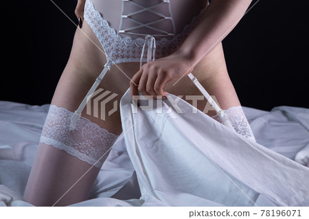 Photo of adult woman in white lingerie covering hips 78196071