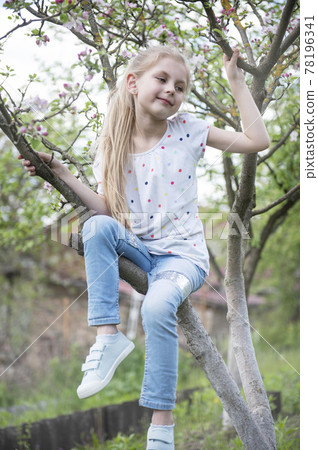 Little adorable girl sitting on blossoming tree Little adorable girl sitting on blossoming tree 78196341