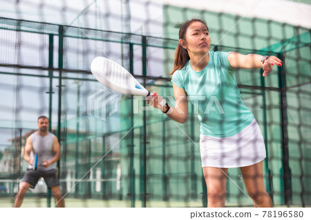 View through tennis net of an female playing padel View through tennis net of an female playing padel 78196580