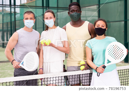 Team of men and women in protective mask after playing padel on the tennis court Team of men and women in protective mask after playing padel on the tennis court 78196753