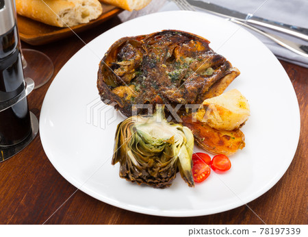 Spanish dish - lamb head with artichoke, tomatoes and potatoes 78197339