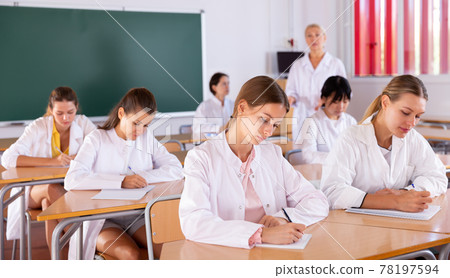 Medical students writing in notepads Medical students writing in notepads 78197594