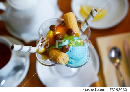 Dessert of two scoops of ice cream, waffle and chocolate candy Dessert of two scoops of ice cream, waffle and chocolate candy 78198080