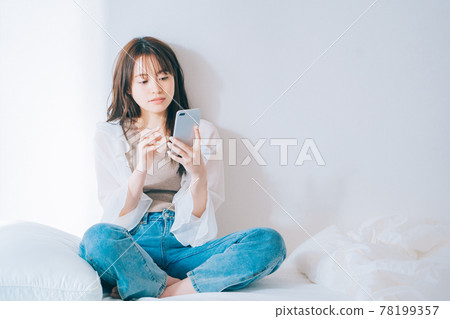 A young woman using a smartphone 78199357