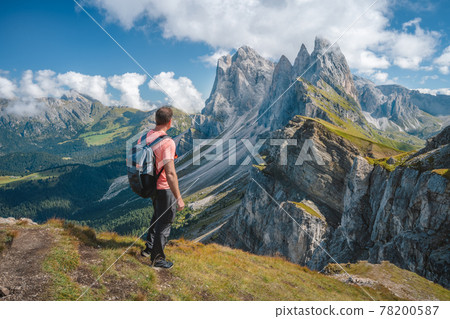 A man with backpack enjoy landscape of Seceda peak in Dolomites Alps, Odle mountain range, South Tyrol, Italy, Europe. Travel vacation concept 78200587