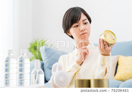 一位婦女在家裡檢查防災用品、疏散用品和應急食品的庫存 一位婦女在家裡檢查防災用品、疏散用品和應急食品的庫存 78206481