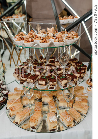 Sweet cakes at a wedding banquet. Catering, sweet festive buffet. Candy bar Sweet cakes at a wedding banquet. Catering, sweet festive buffet. Candy bar 78207918