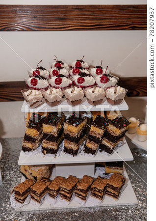 Sweet cakes at a wedding banquet. Catering, sweet festive buffet. Candy bar Sweet cakes at a wedding banquet. Catering, sweet festive buffet. Candy bar 78207937