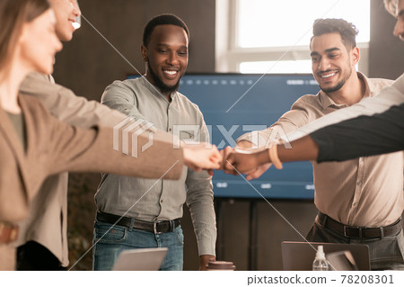 Diverse business people giving fist bump in circle Diverse business people giving fist bump in circle 78208301