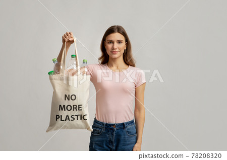 Young Smiling Female Carrying Eco Tote Bag With No More Plastic Incription 78208320