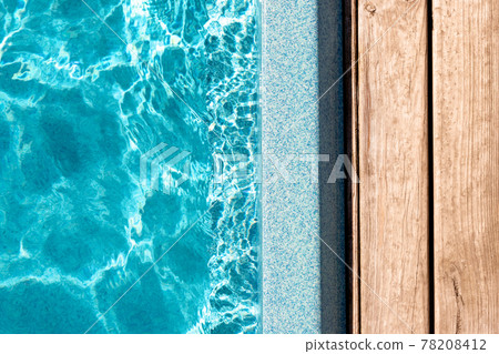 New modern fiberglass plastic swimming pool entrance step with clean fresh refreshing blue water on bright hot summer day at yard or resort hotel spa area. Wooden flooring deck of teak or larch board New modern fiberglass plastic swimming pool entrance step with clean fresh refreshing blue water on bright hot summer day at yard or resort hotel spa area. Wooden flooring deck of teak or larch board 78208412