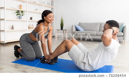 Cool black guy doing core exercises with his girlfriend, working out as team indoors, panorama Cool black guy doing core exercises with his girlfriend, working out as team indoors, panorama 78208454