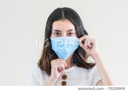 young  beautiful asian woman showing how to wear a medical mask or  showing how to correctly wear hygiene surgical mask step by step on white background 78209909