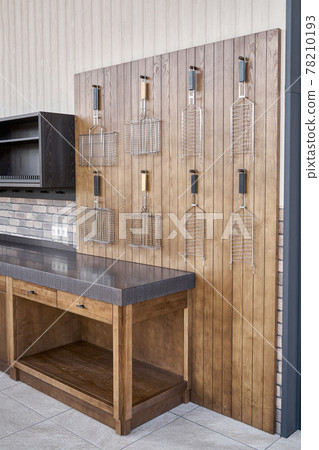 Barbecue grids hang on wainscoting in summer kitchen Barbecue grids hang on wainscoting in summer kitchen 78210193