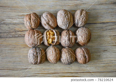 Walnuts closeup on a wooden background, selective focus 78210624