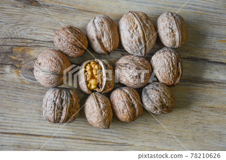 Walnuts closeup on a wooden background, selective focus 78210626