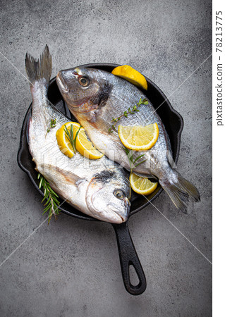 Raw fish sea bream or dorado in cast iron skillet from above Raw fish sea bream or dorado in cast iron skillet from above 78213775