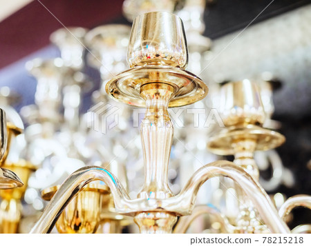 Fragment of golden shiny candelabrum on blurred background Fragment of golden shiny candelabrum on blurred background 78215218