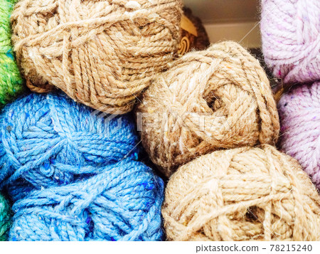 Skeins of blue light brown and lilac woolen yarn. Photo close-up in full screen 78215240