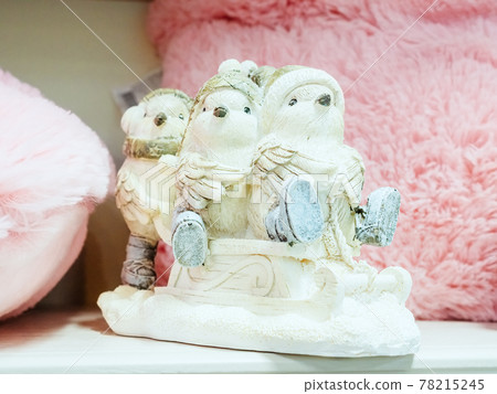 Three fabulous birds in hats and boots are sledding. Ceramic figurine 78215245