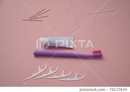 Personal oral hygiene product on a pink background. Toothbrush tube toothpaste toothpick and floss. Flat lay. Copy space Personal oral hygiene product on a pink background. Toothbrush tube toothpaste toothpick and floss. Flat lay. Copy space 78215634