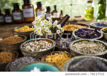 Natural remedy and mortar, healing herbs background Natural remedy and mortar, healing herbs background 78217532