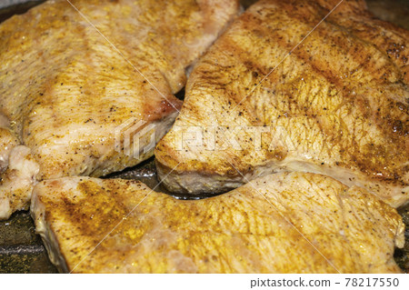 meat pieces fried in a grill pan close up 78217550