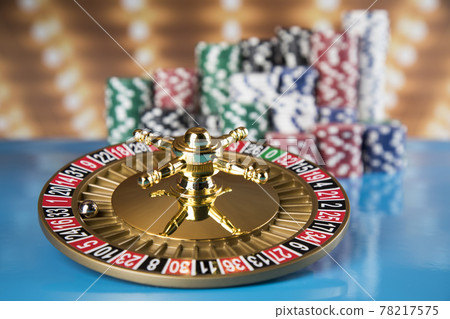 Poker Chips on gaming table, roulette wheel in motion, casino background Poker Chips on gaming table, roulette wheel in motion, casino background 78217575