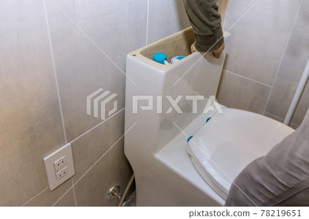 A nstalling new flush toilet bathroom of installation a new white toilet bowl. unfinished interior repair 78219651