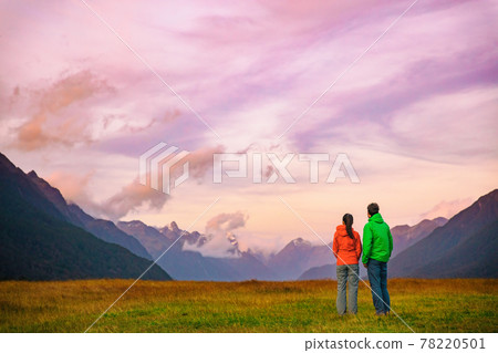 New Zealand hikers backpackers tramping on Routeburn Track, famous trail in the South Island of New Zealand. Couple looking at nature landscape. Fiordland and Mount Aspiring National Park, New Zealand 78220501