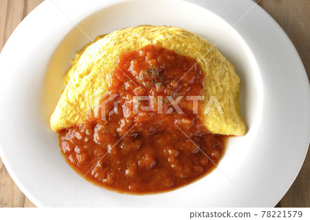 Take a bird's-eye view of an omelet rice or omelet with meat sauce on a wooden board 78221579
