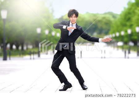一個穿著西裝在街上跳舞的年輕人 78222273