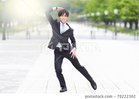 一個穿著西裝在街上跳舞的年輕人 78222302