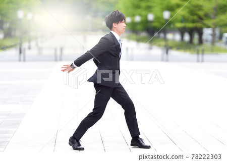 一個穿著西裝在街上跳舞的年輕人 一個穿著西裝在街上跳舞的年輕人 78222303