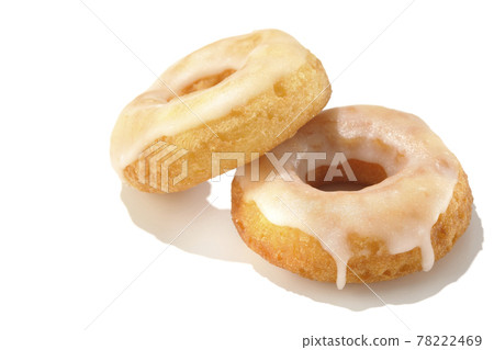 Two overlapping honey glaze donuts shot in summery light and white background 78222469