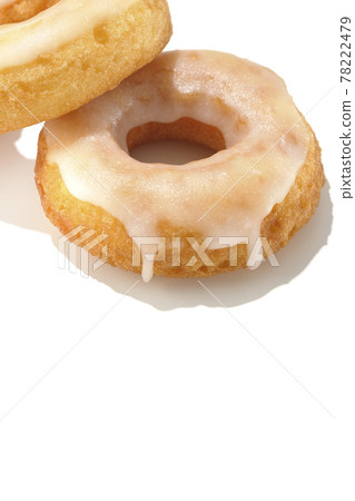 Two overlapping honey glaze donuts shot in summery light and white background 78222479