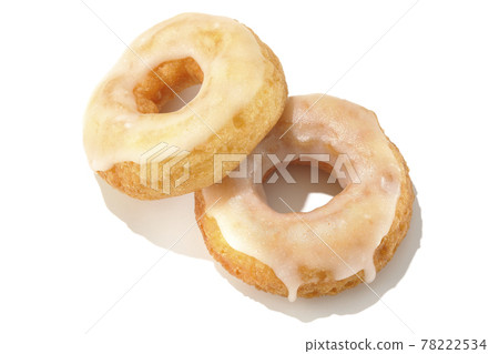 A bird's-eye view of two overlapping honey glaze donuts with summery light and a white background (cutout material) 78222534