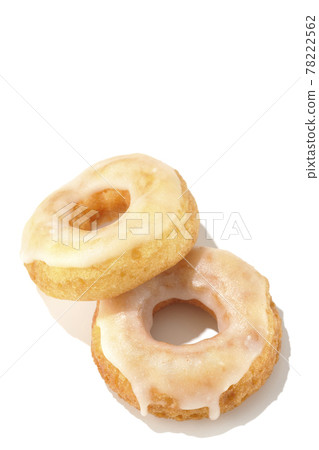 兩個重疊的蜂蜜釉甜甜圈的鳥瞰圖,帶有夏日光線和白色背景 兩個重疊的蜂蜜釉甜甜圈的鳥瞰圖,帶有夏日光線和白色背景 78222562