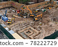 Excavators digging on skyscraper construction site with foundation pit 78222729
