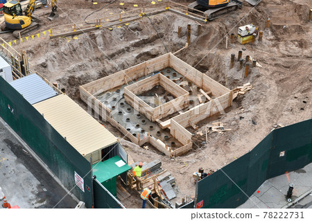 Excavators digging on skyscraper construction site with foundation pit Excavators digging on skyscraper construction site with foundation pit 78222731