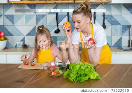 The child learns to cook under the guidance of a parent. 78222929