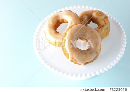 A bird's-eye view of the honey glaze donuts served on the cake stand A bird's-eye view of the honey glaze donuts served on the cake stand 78223056