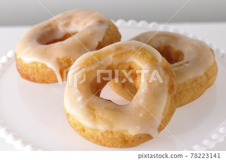 Photographed honey glaze donuts served on a cake stand on a white background Photographed honey glaze donuts served on a cake stand on a white background 78223141