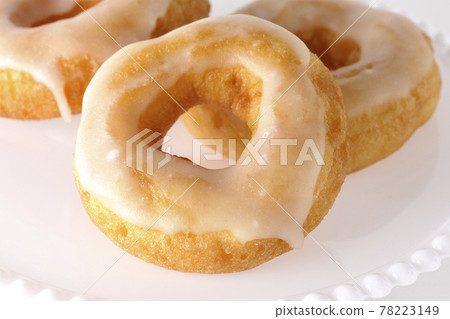 Photographed honey glaze donuts served on a cake stand on a white background Photographed honey glaze donuts served on a cake stand on a white background 78223149
