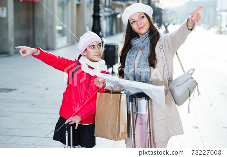 girl with mother holding map outdoors 78227008