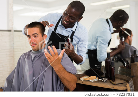 Male client getting haircut from African hairstylist Male client getting haircut from African hairstylist 78227031