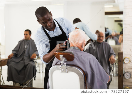 African hairdresser cutting with clipper African hairdresser cutting with clipper 78227197