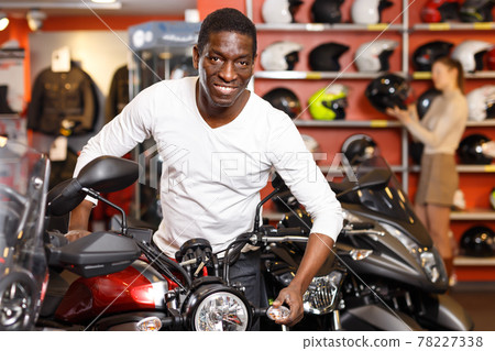 Lucky Afro American man posing near motorcycle Lucky Afro American man posing near motorcycle 78227338