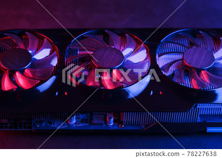 Large and powerful graphics card with three fans with blue pink light. Large and powerful graphics card with three fans with blue pink light. 78227638
