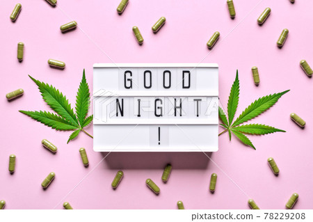 Cannabis extract capsules, hemp leaves and GOOD NIGHT letters lightbox. Calming, anti-stress and sleeping concept 78229208